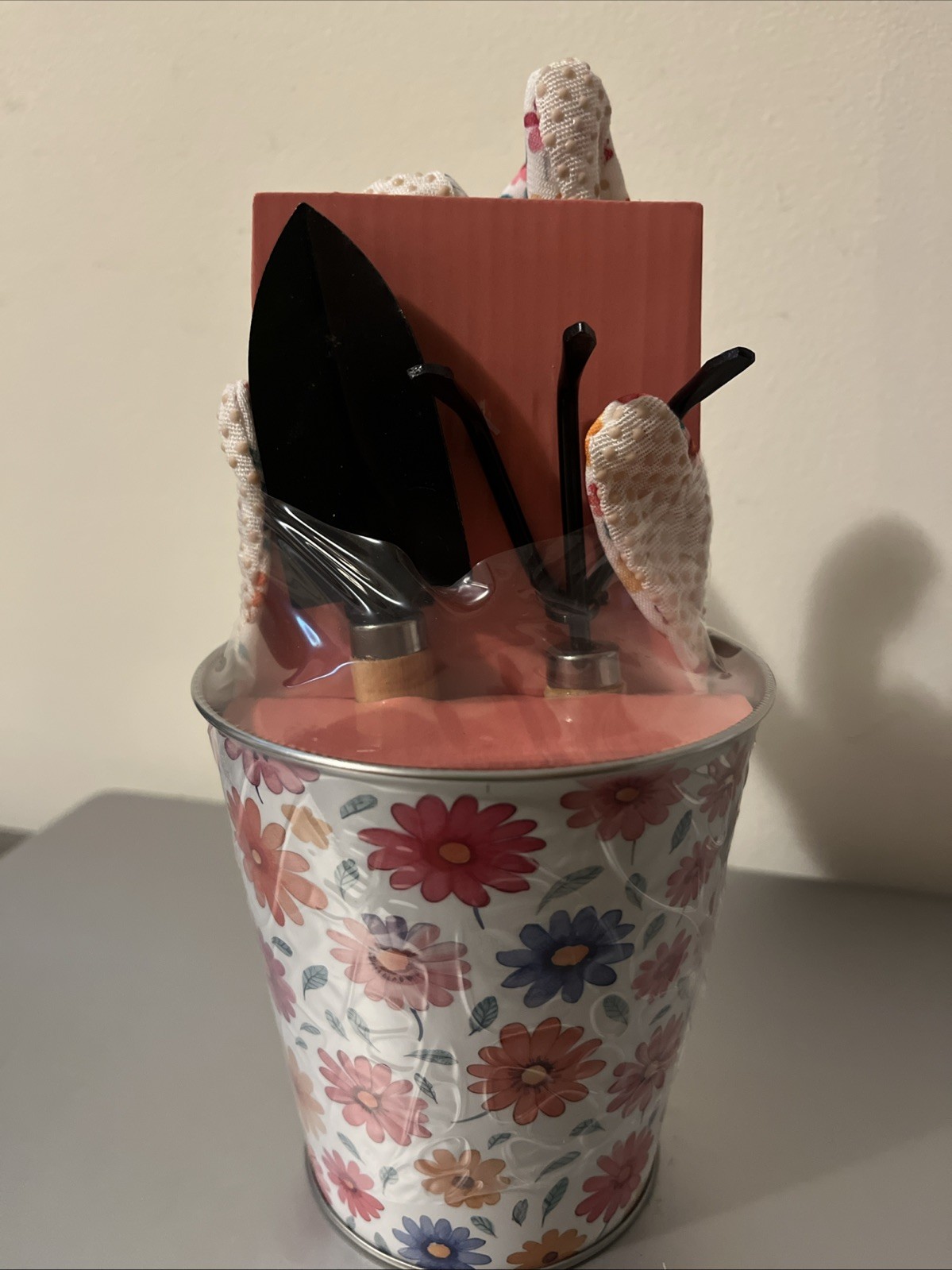 Small Garden Tools Including Gloves Situated Inside Metal Canister.